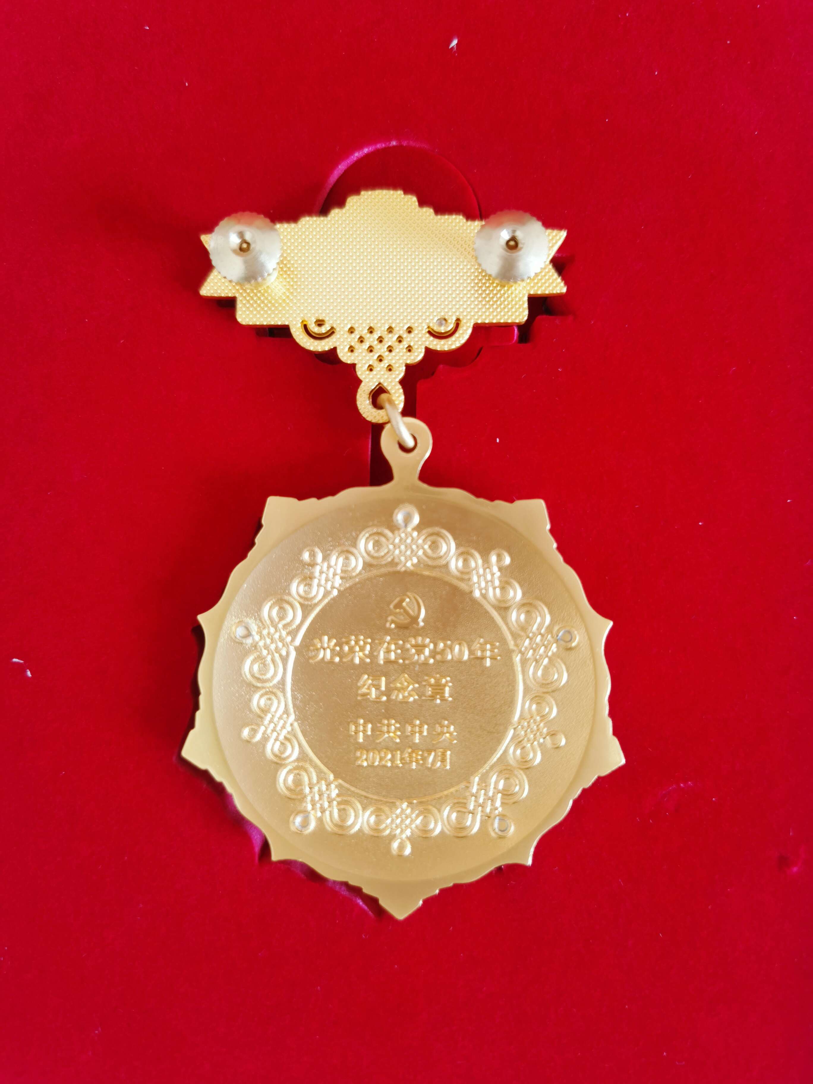 光榮在黨50年紀念獎章背面。  閆慧/攝