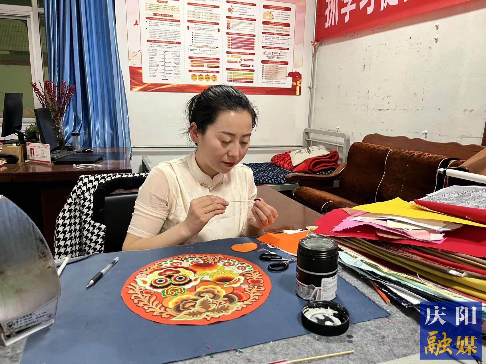 李慶英正在創(chuàng)作布貼畫作品。